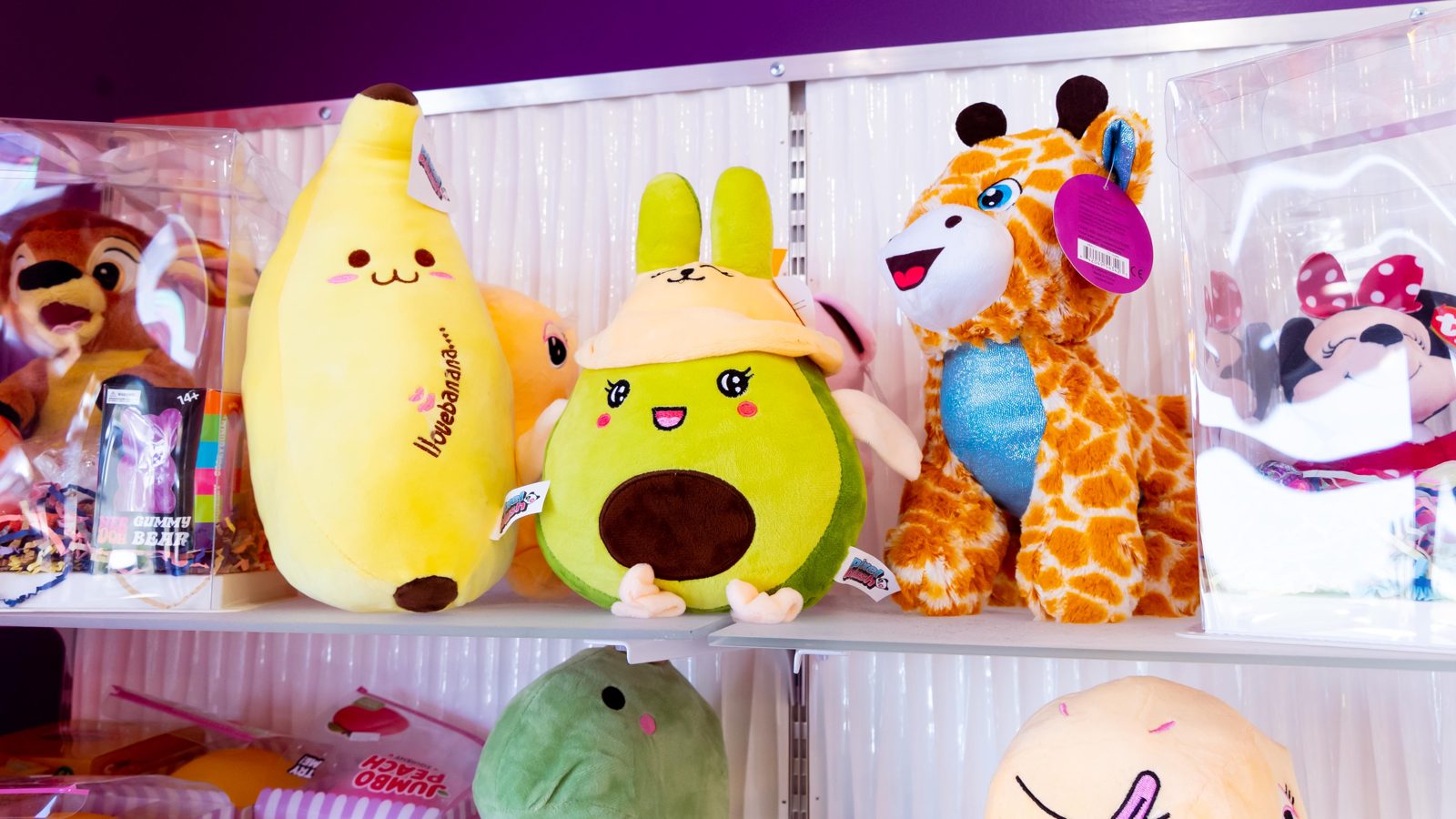 Shelf of squishy plush toys including a banana, avocado and giraffe