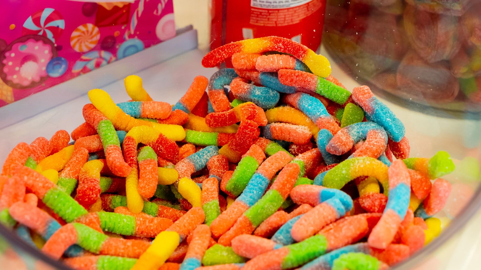 Rainbow sour gummy worms in a bulk candy bowl
